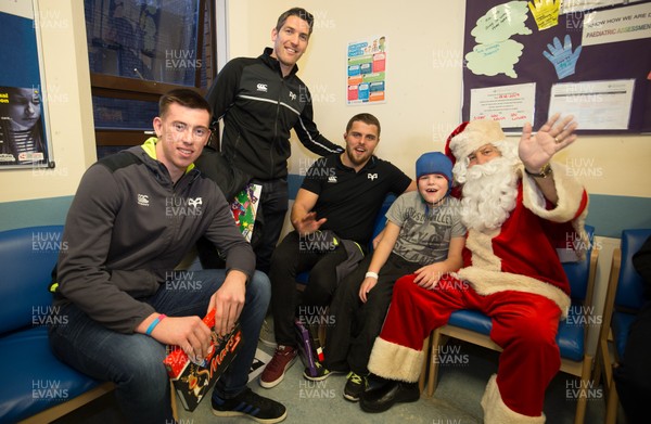 131217 - Ospreys players visit children at Morriston Hospital, Swansea - Ospreys Adam Beard, James Hook and Nicky Smith along with Father Christmas meet Rhys Reid from Neath during their visit to the Children's Ward at Morriston Hospital