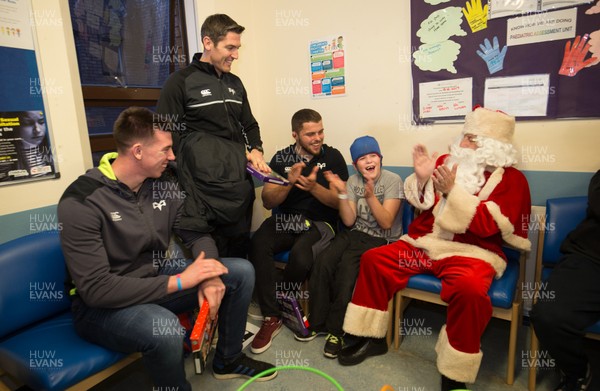 131217 - Ospreys players visit children at Morriston Hospital, Swansea - Ospreys Adam Beard, James Hook and Nicky Smith along with Father Christmas meet Rhys Reid from Neath during their visit to the Children's Ward at Morriston Hospital