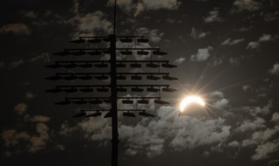 120826 - The partial solar eclipse takes place behind the floodlights of Sophia Gardens Cricket Ground in Cardiff, Wales