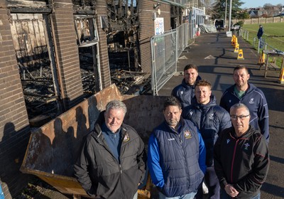 031225 - Penarth RFC Clubhouse Fire - Welsh Rugby Union Community Director Geraint John with Dan Mears, Penarth RFC Secretary and Alan Cozens Penarth RFC Commercial secretary along with Cardiff Rugby and Welsh internationals Mason Grady and Evan Lloyd and Cardiff Rugby Club head coach Corniel van Zyl at the Penarth RFC Clubhouse which was devastated by a recent fire