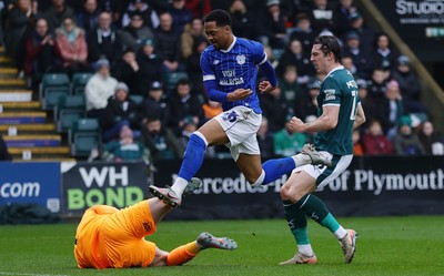 210226 - Plymouth Argyle v Cardiff City - Sky Bet League 1 - Chris Willock of Cardiff City leaps Conor Hazard, Goalkeeper of Plymouth Argyle as he saves