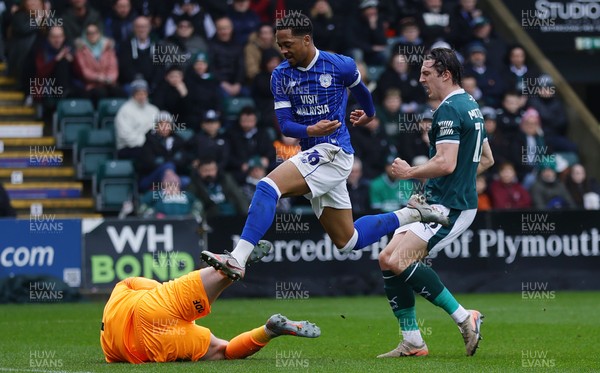 210226 - Plymouth Argyle v Cardiff City - Sky Bet League 1 - Chris Willock of Cardiff City leaps Conor Hazard, Goalkeeper of Plymouth Argyle as he saves