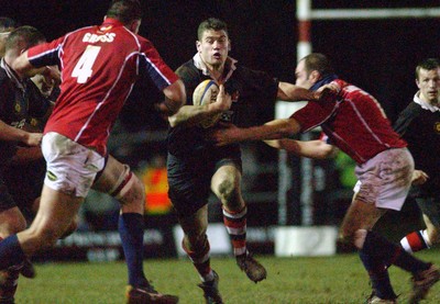 080203 - Pontypool v Llanelli - Principality Cup - Pooler's Lenny Woodard holds off Neil Boobyer as Luke Gross (left) joins to tackle