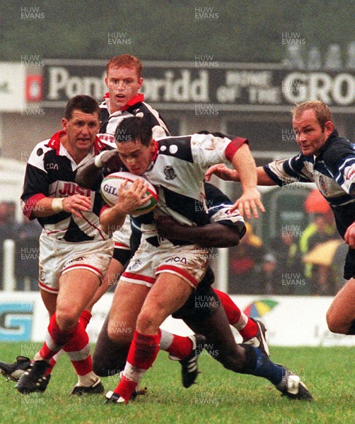 191096 - Pontypridd v Bath - Jason Lewis of Pontypridd is tackled by Adedayo Adebayo