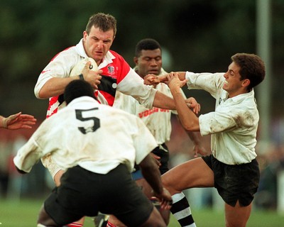 041195 - Pontypridd v Fiji - Greg Prosser of Pontypridd is tackled by Jason McLennan and Levoni Vatureva