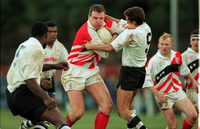 041195 - Pontypridd v Fiji - Greg Prosser of Pontypridd hands off Jason McLennan