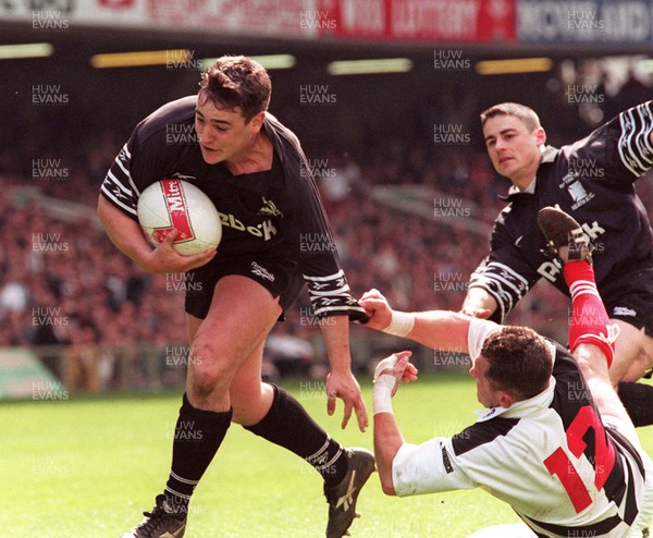 040596 - Pontypridd v Neath - SWALEC Cup Final -  Neath's Richard Jones dives in to score despite the tackle by Steele Lewis 