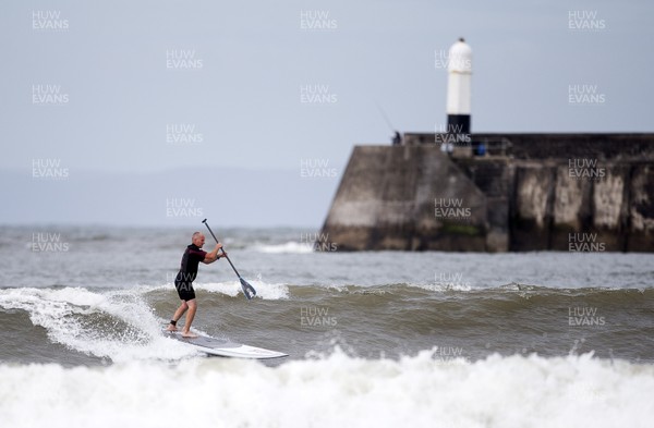 220620 - Picture shows a paddle boarder on the coast at Porthcawl on Monday morning, with temperatures set to sore later this week