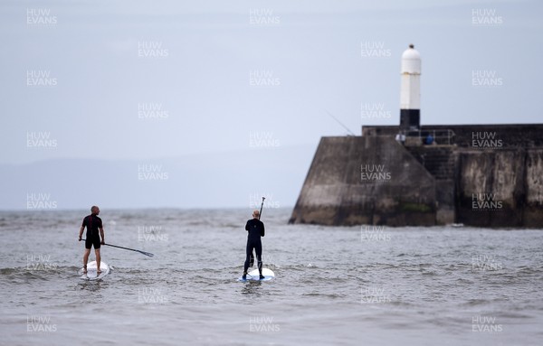 220620 - Picture shows paddle boarders on the coast at Porthcawl on Monday morning, with temperatures set to sore later this week