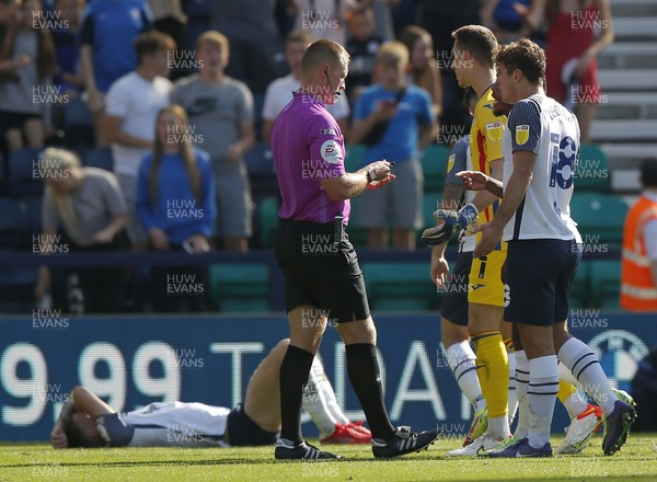 280821 - Preston North End v Swansea City - Sky Bet Championship - Goalkeeper Steven Benda of Swansea gets a yellow card from referee Thomas Bramall whilst Emil Riis Jakobsen of Preston North End lies prone