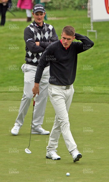 220513 - BMW PGA Golf ChampionshipPro-Celebrity Event - Arsenal and Wales footballer Aaron Ramsey sizes up a putt watched by Justin Rose