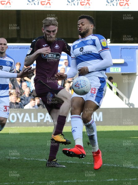 130419 - Queens Park Rangers v Swansea City, Sky Bet Championship - Oli McBurnie of Swansea City and Jordan Cousins of Queens Park Rangers compete for the ball