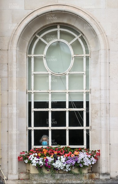 160921 - Picture shows a women wearing a face mask looking out the window as the Red Arrows flew over Cardiff City Hall to open a new exhibition of Wales's effort in the Battle of Britain