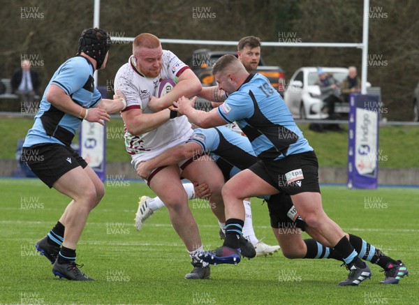 250323 - RGC v Cardiff - WRU Premiership Cup - Pedr Jones of RGC is tackled by Scott Andrews  and Marc Thomas of Cardiff RFC