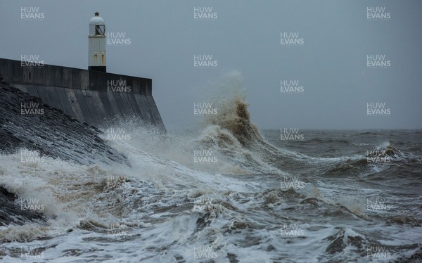 100321 Rough seas pound the coastline around the lighthouse at Porthcawl, south Wales as large parts of the country are expected to hit by rain and strong winds overnight