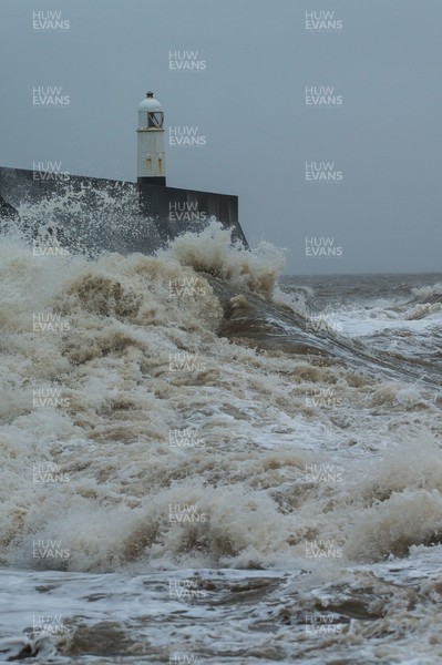 100321 Rough seas pound the coastline around the lighthouse at Porthcawl, south Wales as large parts of the country are expected to hit by rain and strong winds overnight