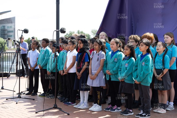 190723 - Cardiff Bay Rugby Codebreakers Statue Unveiling - Local schoolchildren sing at the unveiling of a statue in Cardiff Bay to celebrate the achievements of rugby players from Cardiff Bay who joined rugby league teams