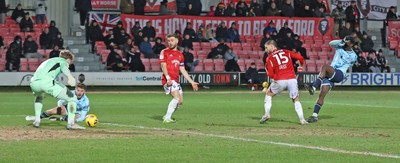 170226 - Salford City v Newport County - Sky Bet League 2 - Nathan Opoku of Newport shoots the ball through the legs of Goalkeeper Matthew Young of Salford for Newport’s 3rd goal