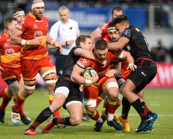 270118 - Saracens v Dragons - Anglo Welsh Cup - Harri Keddie (C) of Dragons is tackled by Max Malin and Reuben Bird Tulloch of Saracens