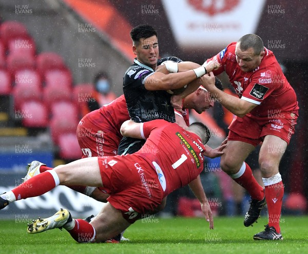080521 - Scarlets v Ospreys - Guinness PRO14 Rainbow Cup - Tiaan Thomas-Wheeler of Ospreys is tackled by Rob Evans and Ken Owens of Scarlets