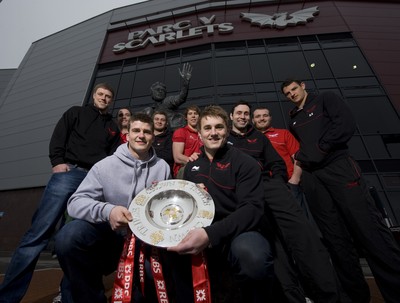 280212 - Scarlets Triple Crown Photocall -Rhys Priestland, Lou Reed, Scott Williams, Rhodri Jones, Liam Williams, Jonathan Davies, Stephen Jones, Ken Owens and Aaron Shingler of Wales and Scarlets with the triple crown next to the Ray Gravell statue outside Parc y Scarlets