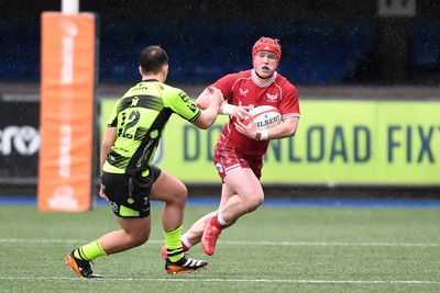 230225 - Scarlets U18s v Dragons U18s - Regional Age-Grade Championship finals - Osian Williams of Scarlets U18s is challenged by David Petrescu of Dragons U18s