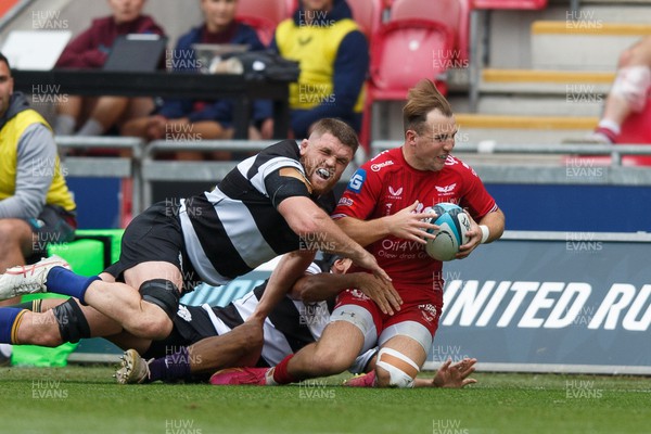 160923 - Scarlets v Barbarians - Phil Bennett Memorial Game - Ioan Lloyd of Scarlets is tackled