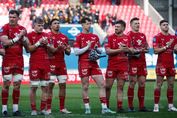 230324 - Scarlets v Benetton - United Rugby Championship -  Alex Craig, Teddy Leatherbarrow, Dan Davis, Tom Rogers, Shaun Evans, Jonathan Davies and Tomi Lewis of Scarlets applaud in memory of Lewis Jones, former Llanelli and Wales player, before the match