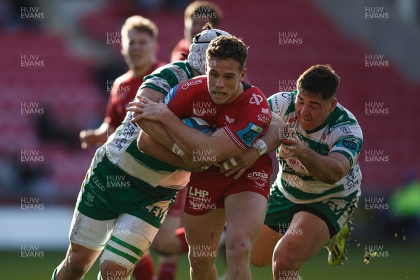 230324 - Scarlets v Benetton - United Rugby Championship - Kieran Hardy of Scarlets is tackled by Manuel Zuliani and Tiziano Pasquali of Benetton