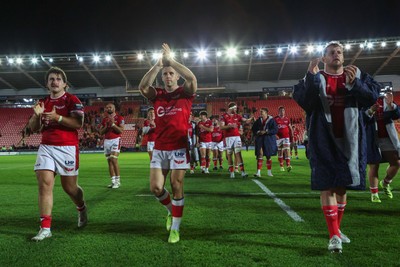 101026 - Scarlets v Benetton Rugby - United Rugby Championship - John McKee, Gareth Davies and Ryan Elias of Scarlets applaud fans at the end of the match