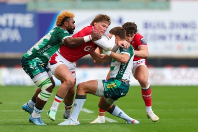 101026 - Scarlets v Benetton Rugby - United Rugby Championship - Ellis Mee of Scarlets is tackled by Onisi Ratave and Francois Carlo Mey of Benetton