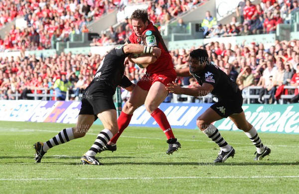 10.10.09 - Scarlets v Brive, Heineken Cup -  Scarlets' Mark Jones is tackled just short of the line by Brive's Jamie Noon (left) and Farbice Estebanez 