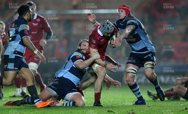 291218 - Scarlets v Cardiff Blues - Guinness PRO14 - Jonathan Davies of Scarlets is tackled by Kristian Dacey and Seb Davies of Cardiff Blues