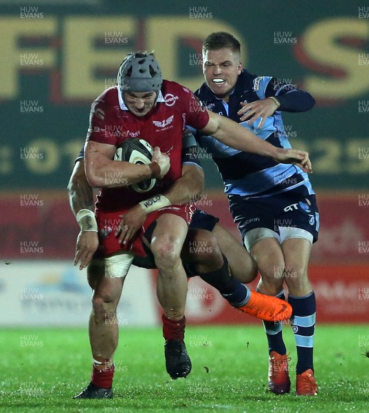 291218 - Scarlets v Cardiff Blues - Guinness PRO14 - Jonathan Davies of Scarlets is tackled by Willis Halaholo and Gareth Anscombe of Cardiff Blues