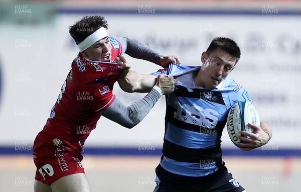 020422 - Scarlets v Cardiff Rugby - United Rugby Championship - Josh Adams of Cardiff is tackled by Tom Rogers of Scarlets 