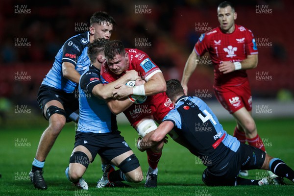 041123 - Scarlets v Cardiff Rugby - United Rugby Championship - Alex Craig of Scarlets is tackled by Thomas Young and Shane Lewis-Hughes of Cardiff
