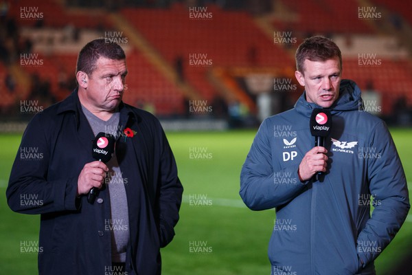 041123 - Scarlets v Cardiff Rugby - United Rugby Championship - Scarlets head coach Dwayne Peel is interviewed after the match as Ospreys head coach, Toby Booth, working as a pundit, looks on