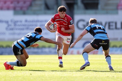 180426 - Scarlets v Cardiff Rugby - United Rugby Championship - Eddie James of Scarlets is tackled by Ben Thomas and Jacob Beetham of Cardiff 