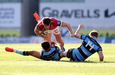 180426 - Scarlets v Cardiff Rugby - United Rugby Championship - Eddie James of Scarlets is tackled by Ben Thomas and Jacob Beetham of Cardiff 