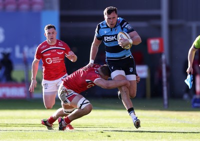 180426 - Scarlets v Cardiff Rugby - United Rugby Championship - Mason Grady of Cardiff is tackled by Jarrod Taylor of Scarlets 