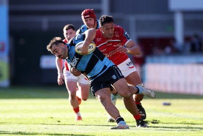 180426 - Scarlets v Cardiff Rugby - United Rugby Championship - Liam Belcher of Cardiff is tackled by Sam Lousi of Scarlets 
