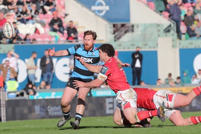 180426 - Scarlets v Cardiff Rugby - United Rugby Championship - Fletcher Anderson of Scarlets offloads under pressure from Rory Jennings of Cardiff Rugby