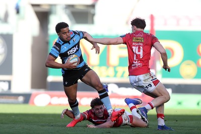 180426 - Scarlets v Cardiff Rugby - United Rugby Championship - Ben Thomas of Cardiff Rugby evades Tom Rogers of Scarlets