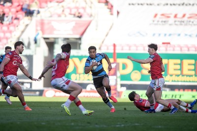 180426 - Scarlets v Cardiff Rugby - United Rugby Championship - Ben Thomas of Cardiff Rugby evades Tom Rogers and attacks Johnny Williams of Scarlets
