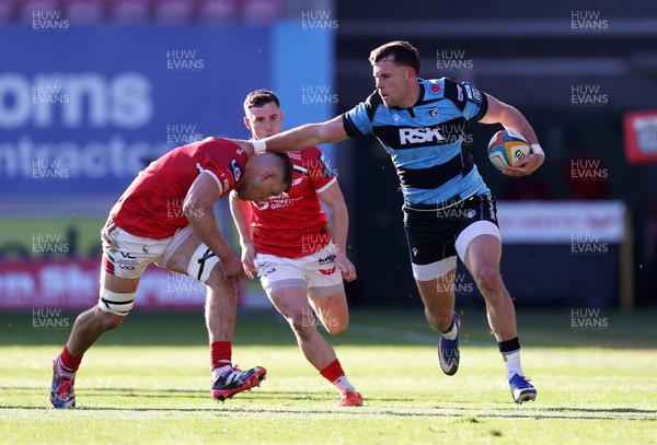 180426 - Scarlets v Cardiff Rugby - United Rugby Championship - Mason Grady of Cardiff is tackled by Jarrod Taylor of Scarlets 