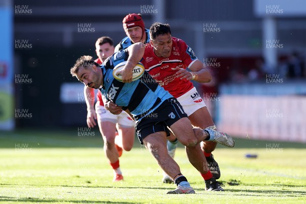 180426 - Scarlets v Cardiff Rugby - United Rugby Championship - Liam Belcher of Cardiff is tackled by Sam Lousi of Scarlets 