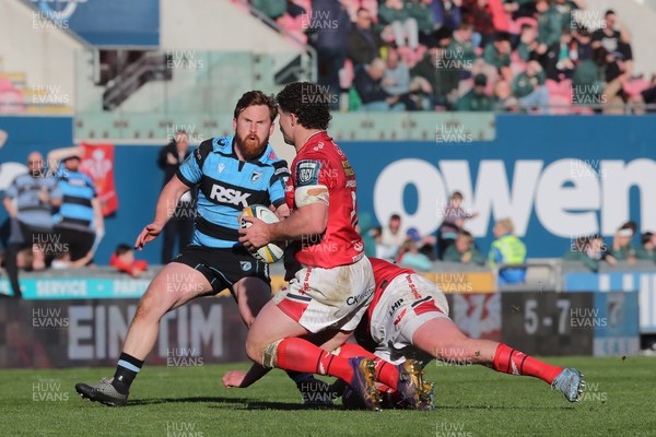 180426 - Scarlets v Cardiff Rugby - United Rugby Championship - Fletcher Anderson of Scarlets offloads under pressure from Rory Jennings of Cardiff Rugby