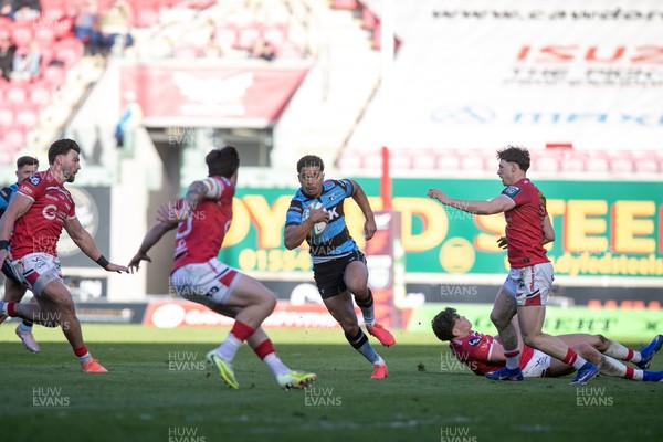 180426 - Scarlets v Cardiff Rugby - United Rugby Championship - Ben Thomas of Cardiff Rugby evades Tom Rogers and attacks Johnny Williams of Scarlets