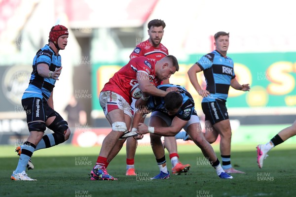 180426 - Scarlets v Cardiff Rugby - United Rugby Championship - Jarrod Taylor of Scarlets is stopped by Mason Grady of Cardiff Rugby