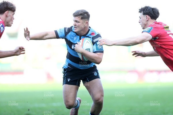 180426 - Scarlets v Cardiff Rugby - United Rugby Championship - Callum Sheedy of Cardiff Rugby hands off Eddie James of Scarlets 